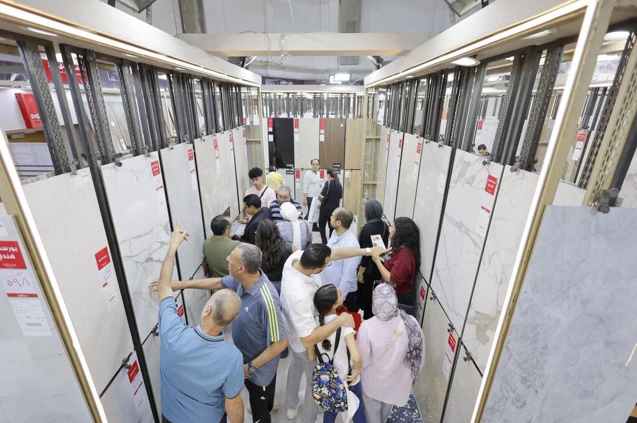 A family comparing large porcelain slabs on display racks