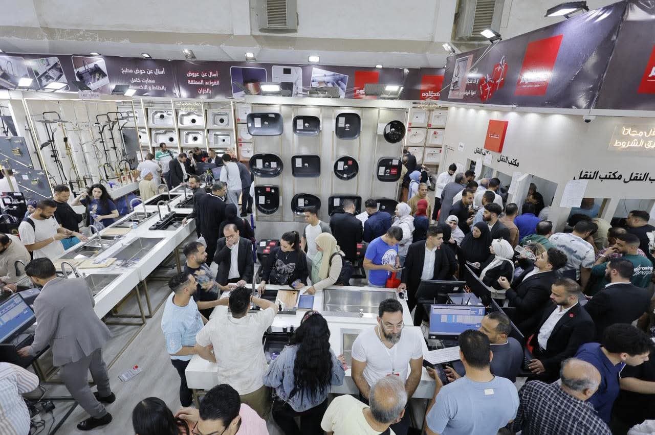 Buyers crowding a stand of sinks and wash basins