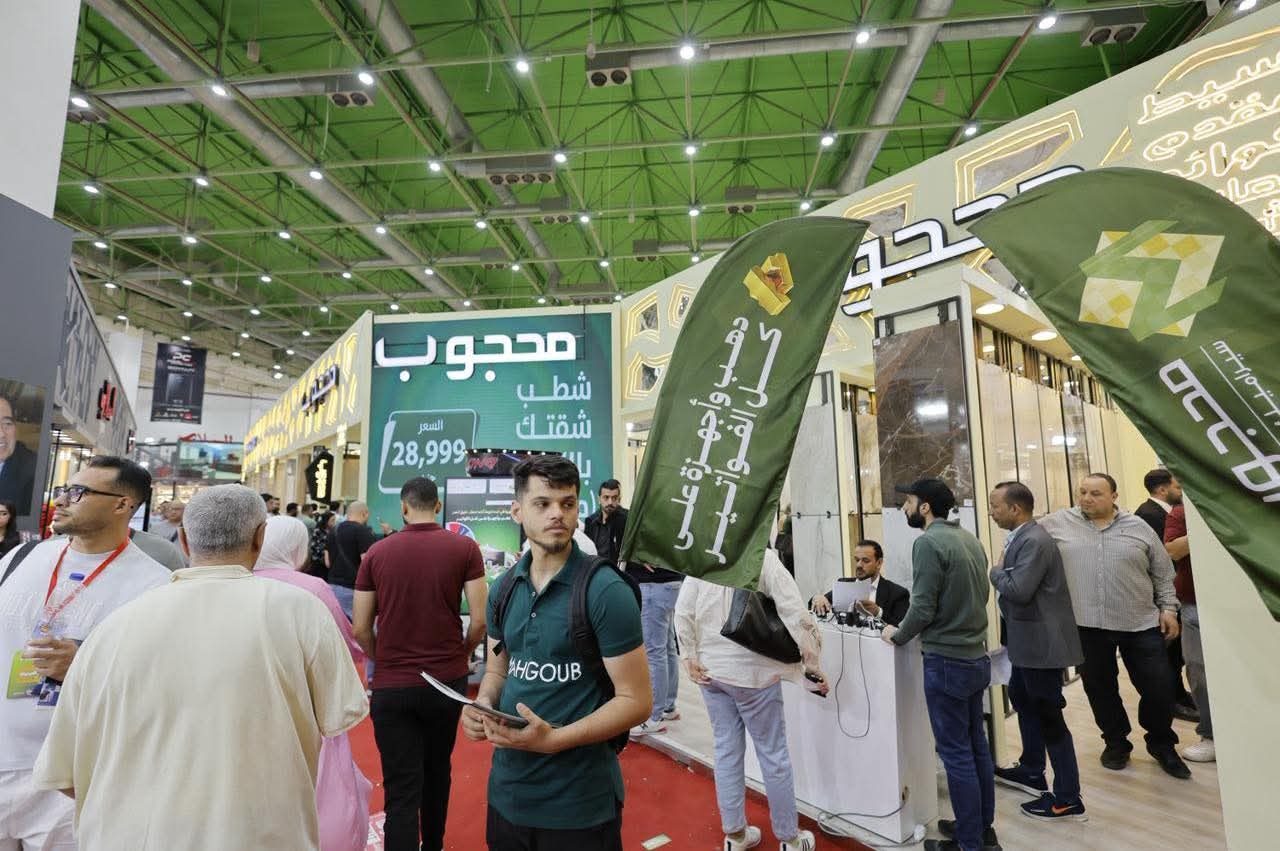 Visitors walking past the Mahgoub stand and its flags