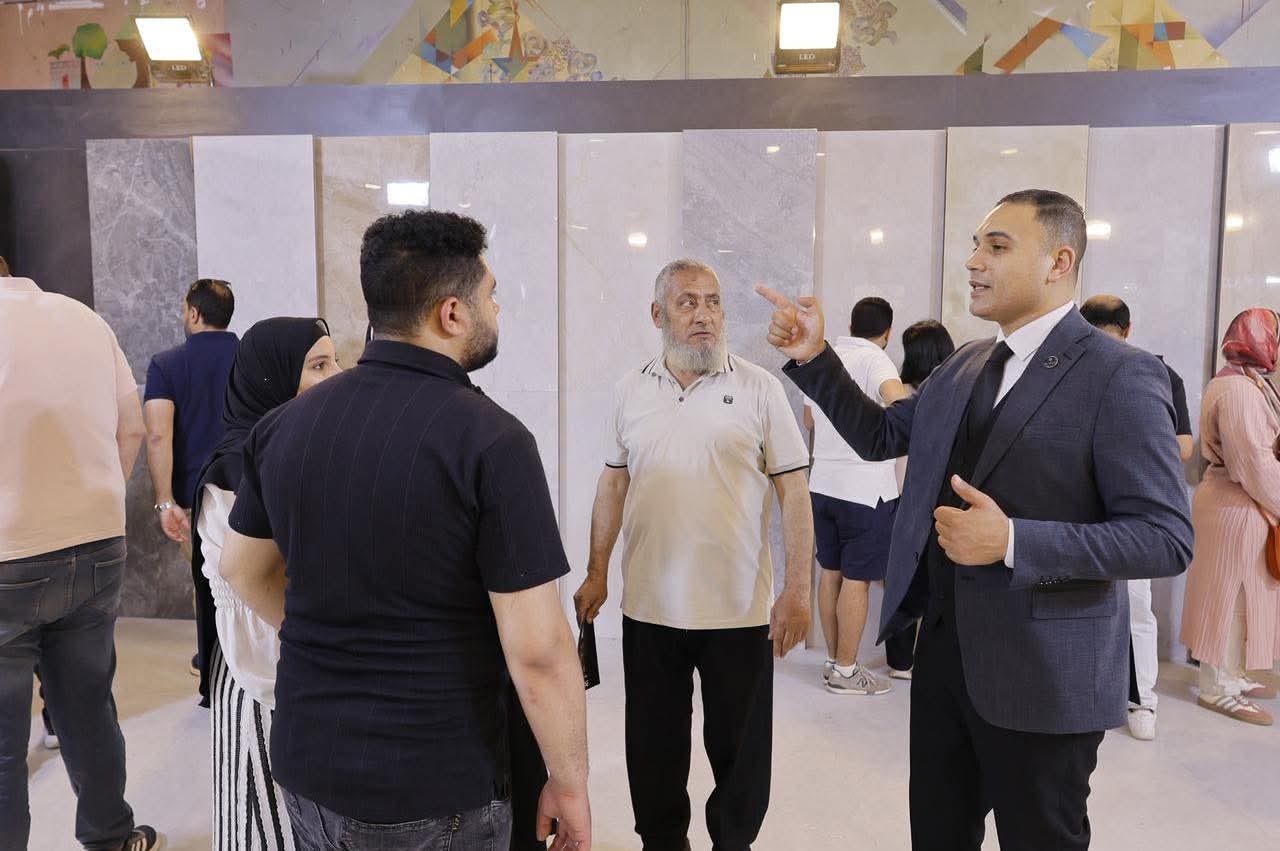 An exhibitor advising a family in front of marble-look porcelain